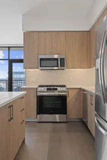a kitchen with granite countertop white cabinets and stainless steel appliances