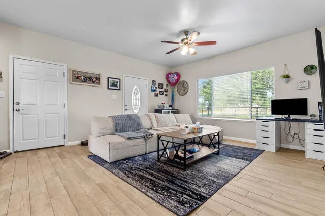 a kitchen with stainless steel appliances granite countertop a stove top oven a sink dishwasher a dining table and chairs with wooden floor