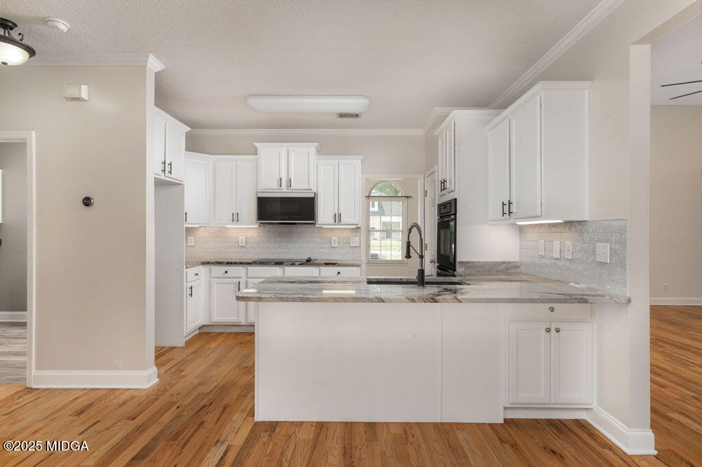 104 Browning Pointe Road Macon, GA 31216 - Photo 3 of 38 a kitchen with stainless steel appliances granite countertop a sink dishwasher a refrigerator and white cabinets with wooden floor