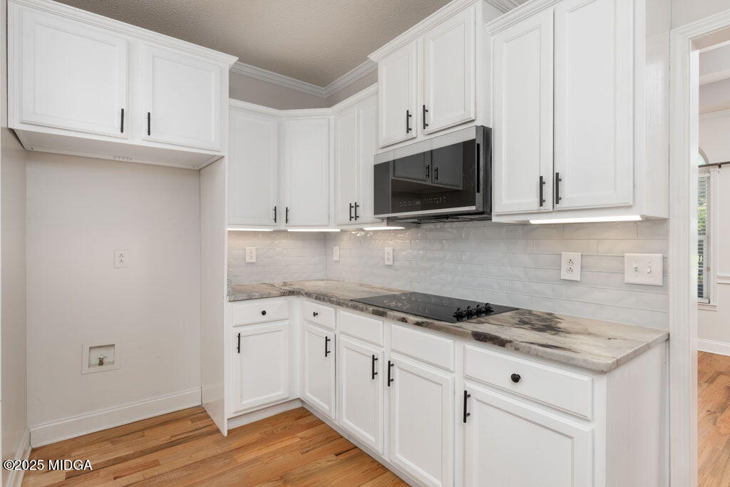 104 Browning Pointe Road Macon, GA 31216 - Photo 38 of 38 a kitchen with granite countertop white cabinets and black appliances
