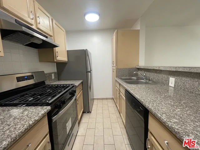 a kitchen with granite countertop a stove and a sink