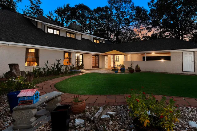 a front view of a house with a garden and yard