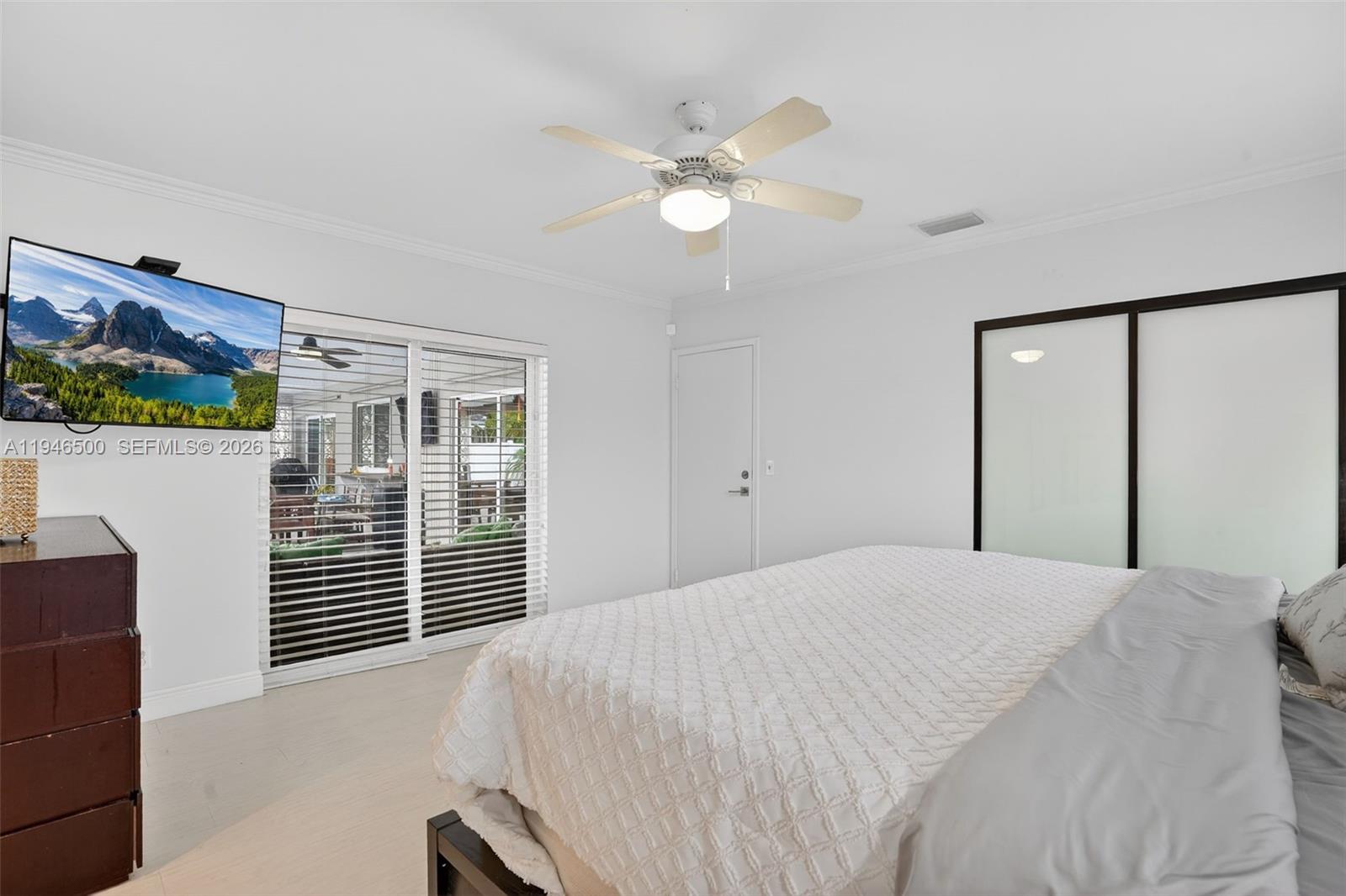 4710 Grant Street Hollywood, FL 33021 - Photo 19 of 56 a bedroom with a large bed and a chandelier