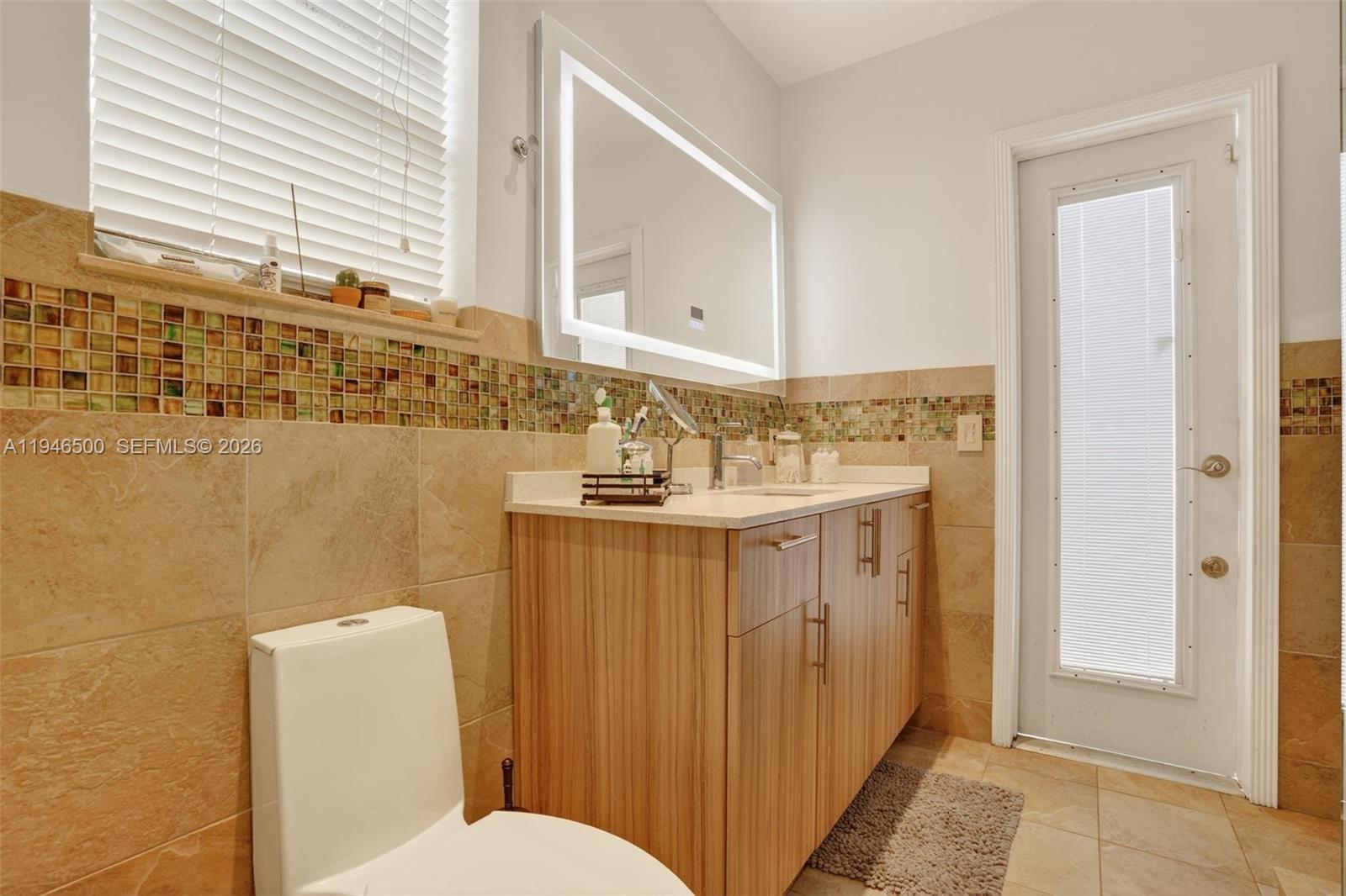 4710 Grant Street Hollywood, FL 33021 - Photo 22 of 56 a bathroom with a sink mirror vanity and toilet
