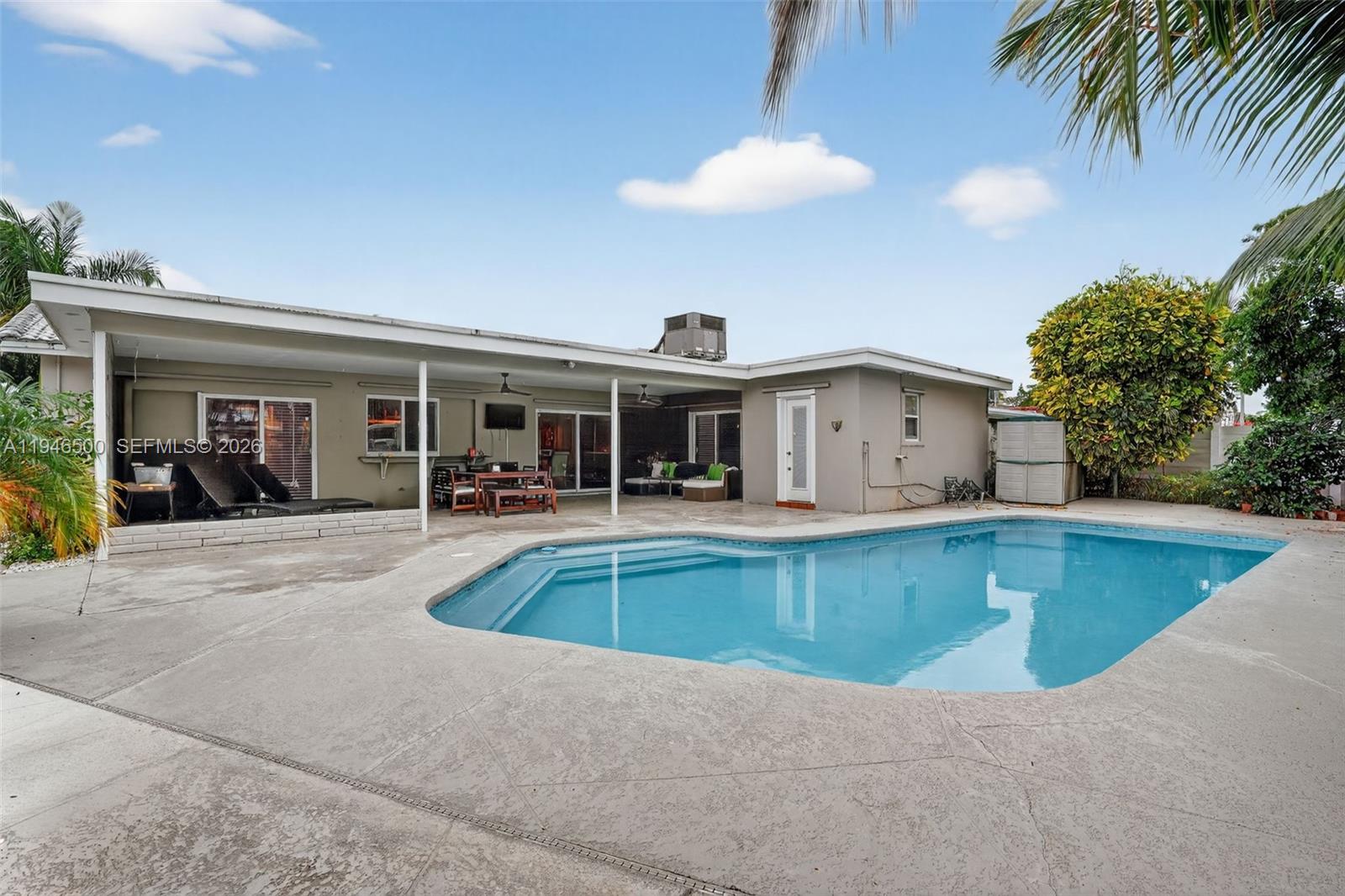 4710 Grant Street Hollywood, FL 33021 - Photo 39 of 56 a view of a house with swimming pool and a chairs and tables in patio