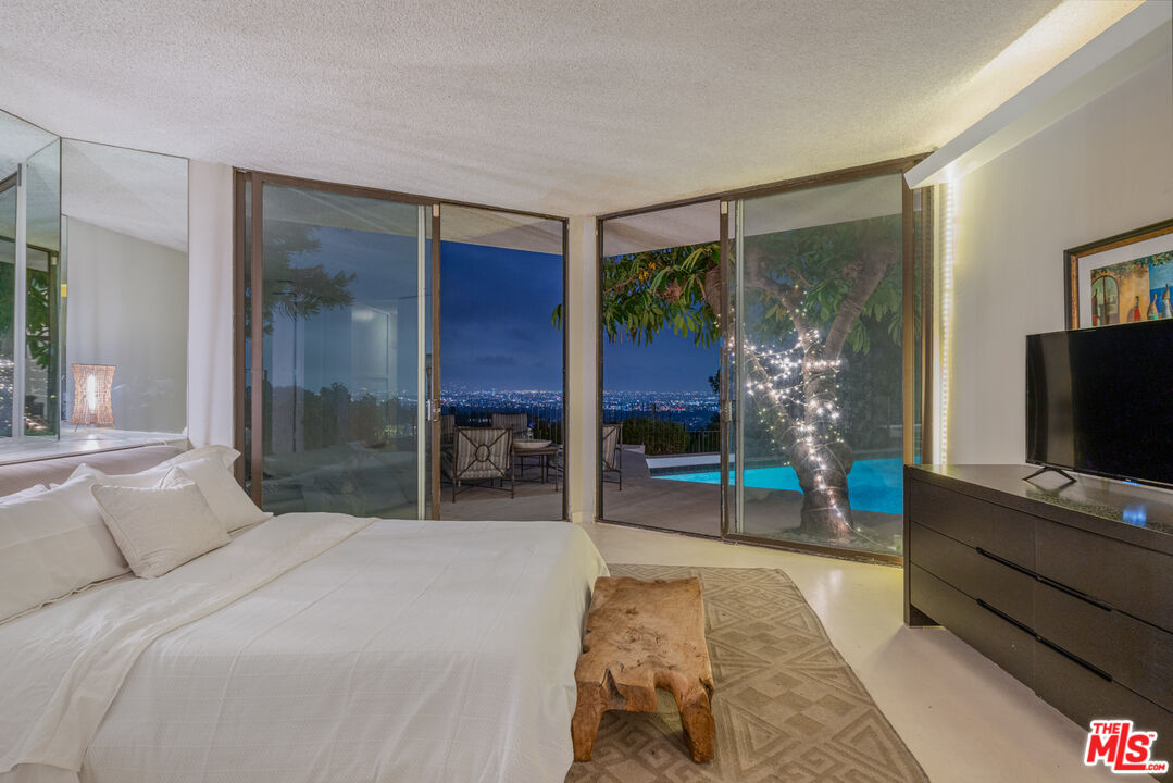 960 Stradella Road Los Angeles, CA 90077 - Photo 14 of 17 a bedroom with a bed and a flat screen tv