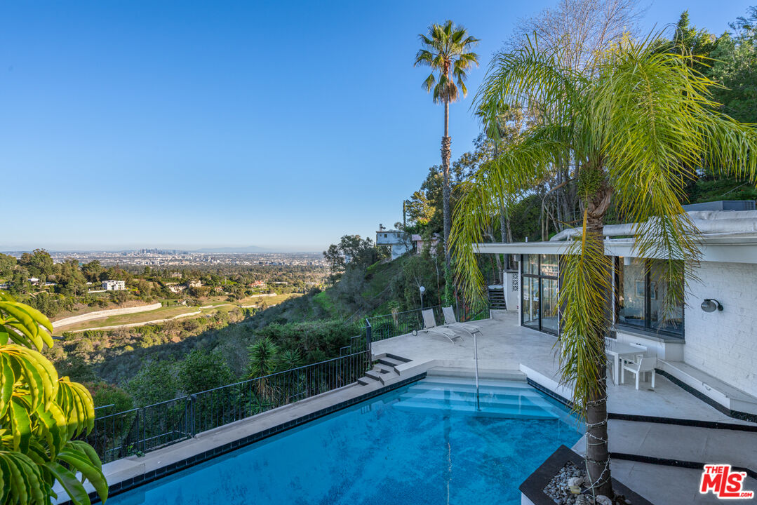 960 Stradella Road Los Angeles, CA 90077 - Photo 10 of 17 a view of a swimming pool with a garden