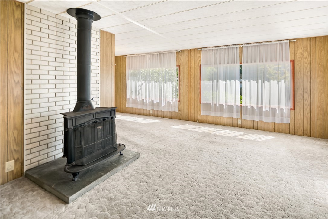 18902 128th Place Northeast Bothell, WA 98011 - Photo 9 of 15 a living room with a fireplace furniture and a floor to ceiling window