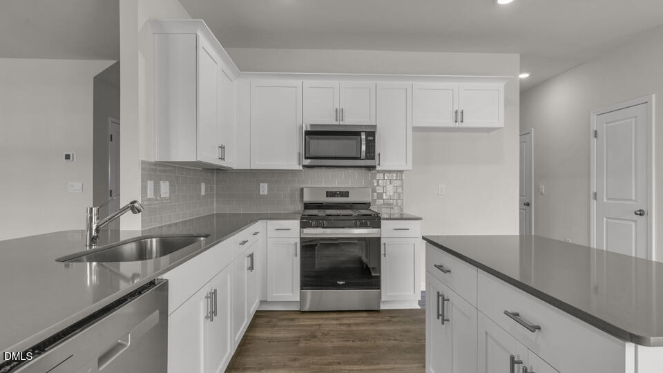 1305 Pavo Path Wendell, NC 27591 - Photo 15 of 55 a kitchen with granite countertop white cabinets and stainless steel appliances