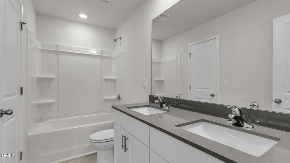 1305 Pavo Path Wendell, NC 27591 - Photo 34 of 55 a bathroom with a sink double vanity granite tub and a toilet