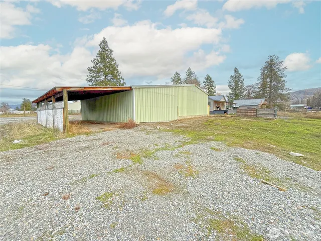 a view of dirt field with large trees