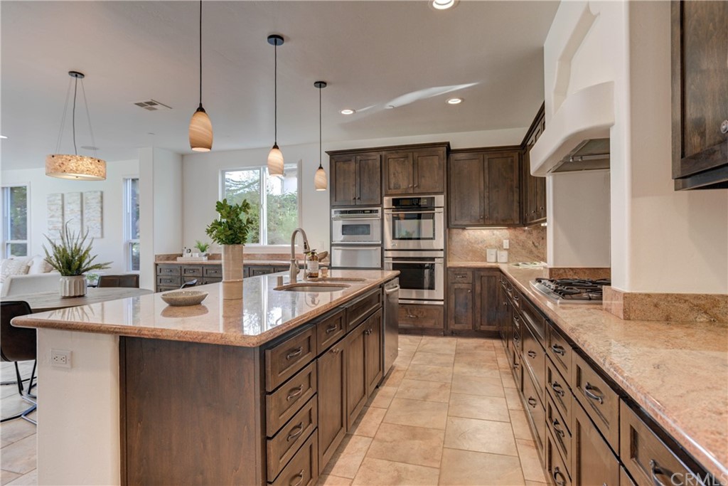 1715 Trilogy Parkway Nipomo, CA 93444 - Photo 28 of 69 a kitchen with kitchen island granite countertop a sink a counter top space appliances and cabinets