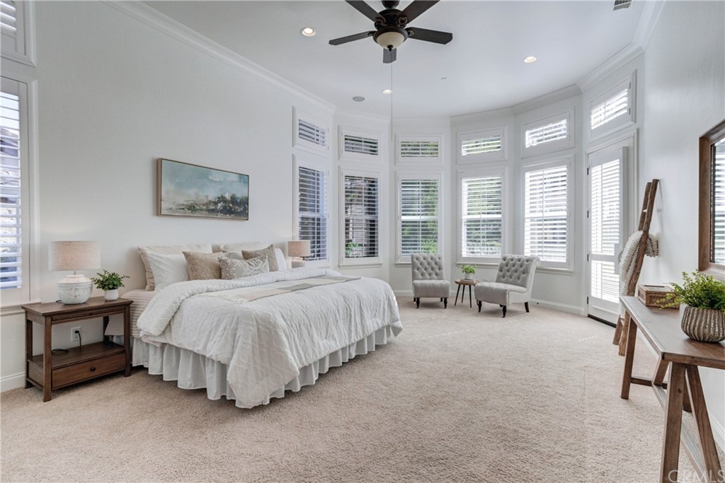 1715 Trilogy Parkway Nipomo, CA 93444 - Photo 43 of 69 a spacious bedroom with a bed a table and a chandelier