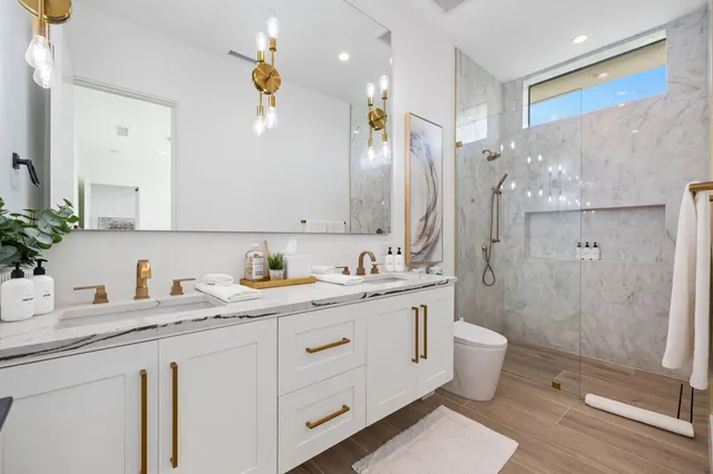 a bathroom with a double vanity sink toilet and shower