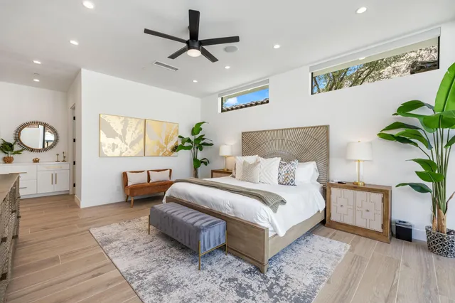 a spacious bedroom with a large bed and a potted plant