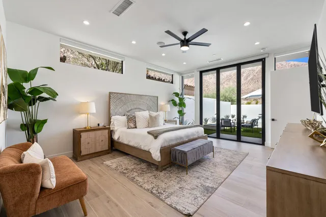 a spacious bedroom with a large bed and a potted plant
