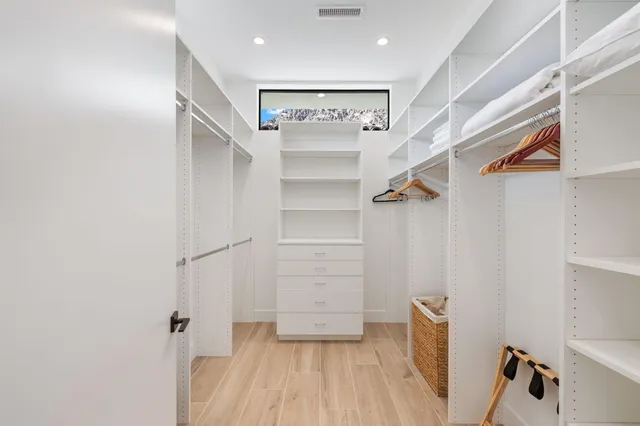 a view of walk in closet with empty racks