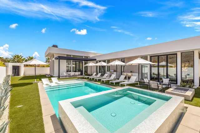 a view of a house with swimming pool and sitting area