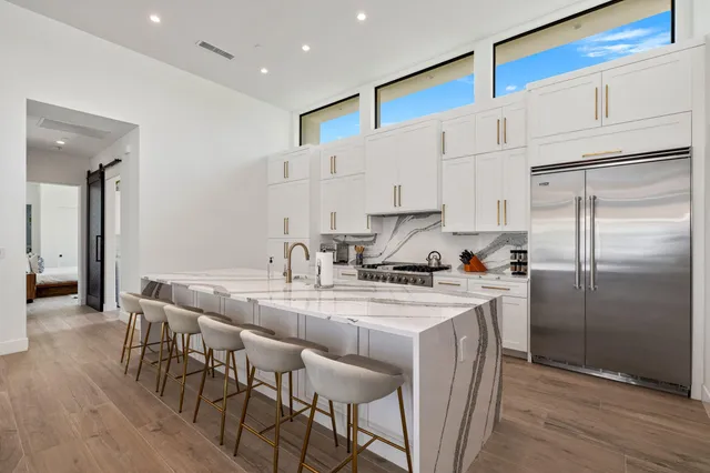 a kitchen with stainless steel appliances granite countertop a white cabinets and a refrigerator