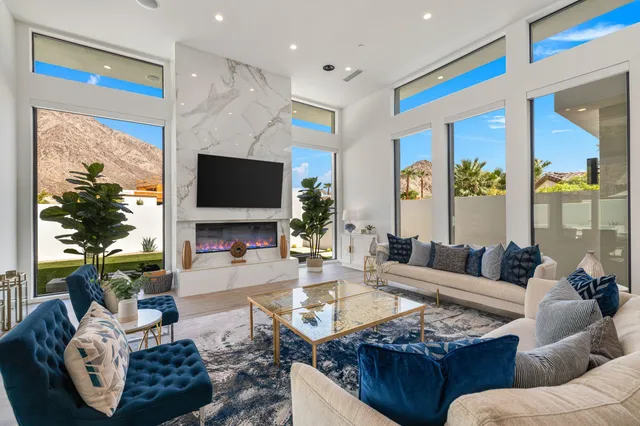 a living room with furniture fireplace and a large window