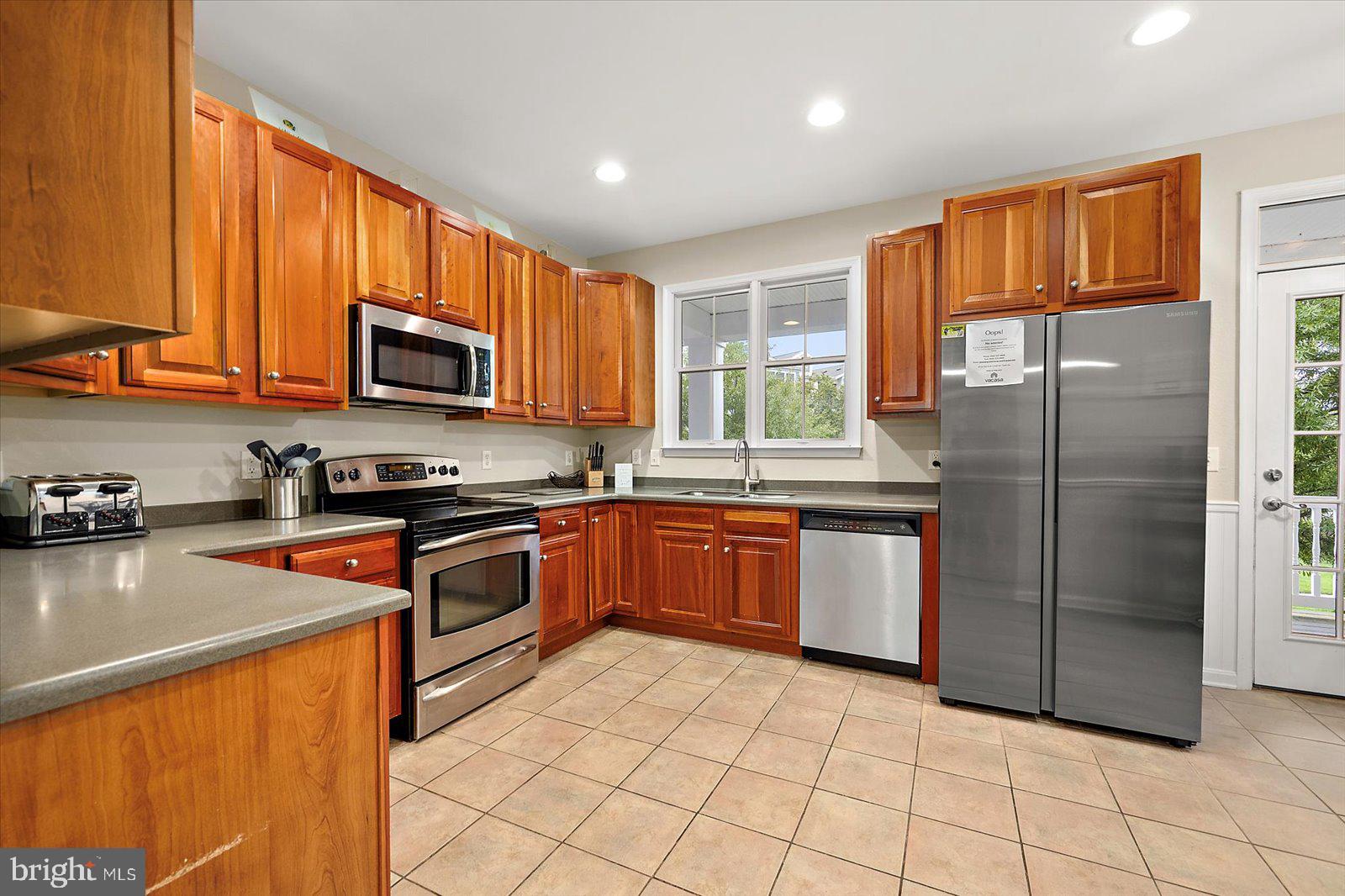 11446 West Sand Cove Road Selbyville, DE 19975 - Photo 22 of 104 a kitchen with stainless steel appliances granite countertop a refrigerator a stove top oven a sink and dishwasher
