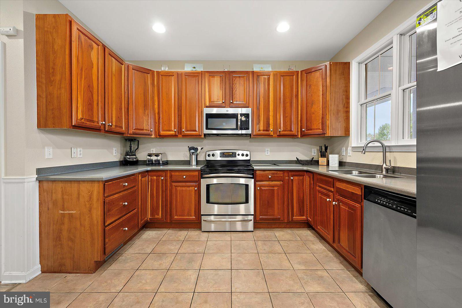 11446 West Sand Cove Road Selbyville, DE 19975 - Photo 24 of 104 a kitchen with stainless steel appliances granite countertop a stove top oven a sink dishwasher and a microwave oven with cabinets