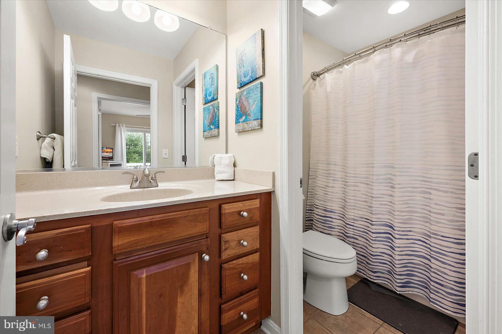 11446 West Sand Cove Road Selbyville, DE 19975 - Photo 43 of 104 a bathroom with a sink a toilet and shower curtain