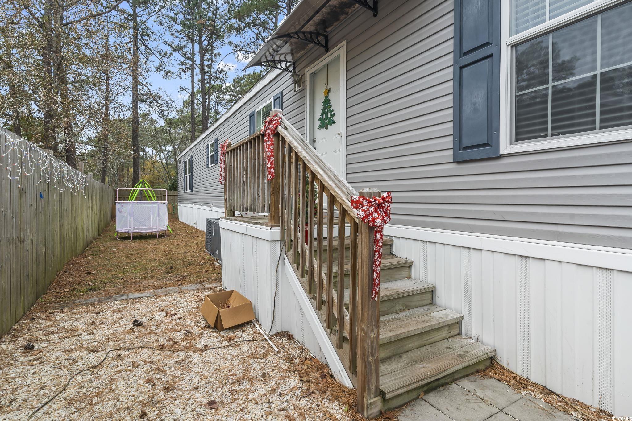 91 Offshore Drive Murrells Inlet, SC 29576 - Photo 23 of 24 View of side of home featuring a fenced backyard and a trampoline