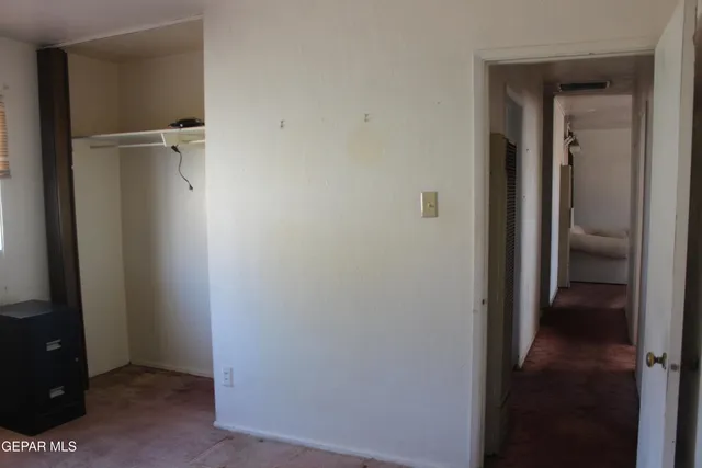 a view of a hallway with closet and mirror