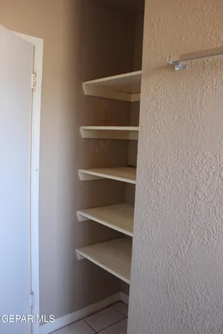 a view of walk in closet with empty racks