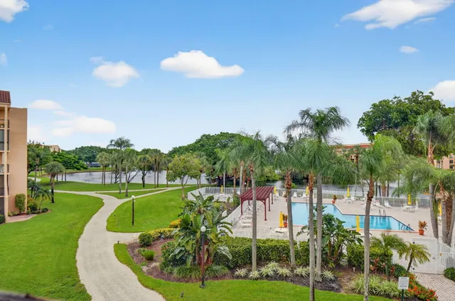 a view of a lake with a big yard and large trees