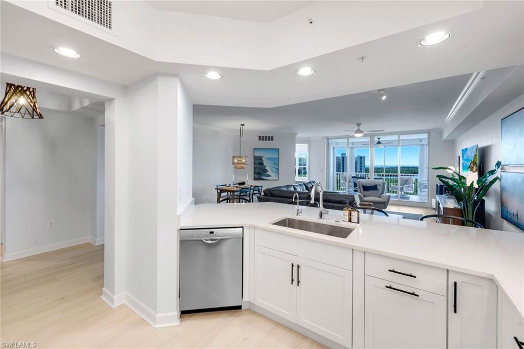 325 Dunes Boulevard, Unit 604 Naples, FL 34110 - Photo 11 of 41 a kitchen with white cabinets and white appliances