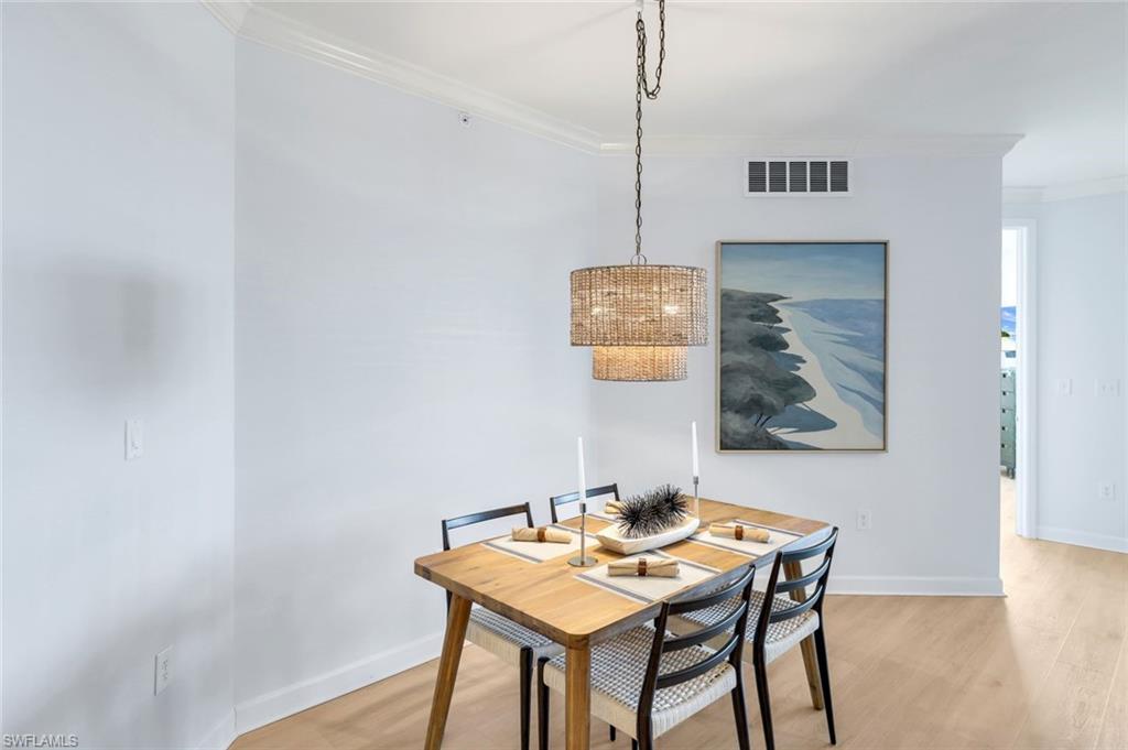 325 Dunes Boulevard, Unit 604 Naples, FL 34110 - Photo 14 of 41 a view of a dining room with furniture and wooden floor
