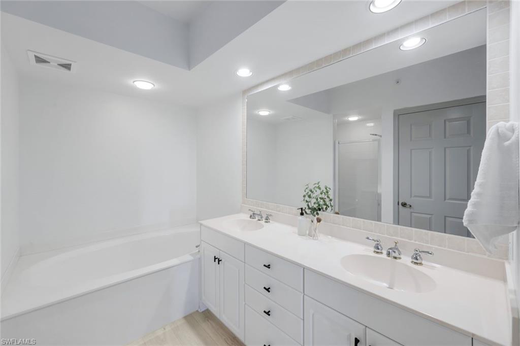 325 Dunes Boulevard, Unit 604 Naples, FL 34110 - Photo 17 of 41 a bathroom with a bathtub a sink and mirror