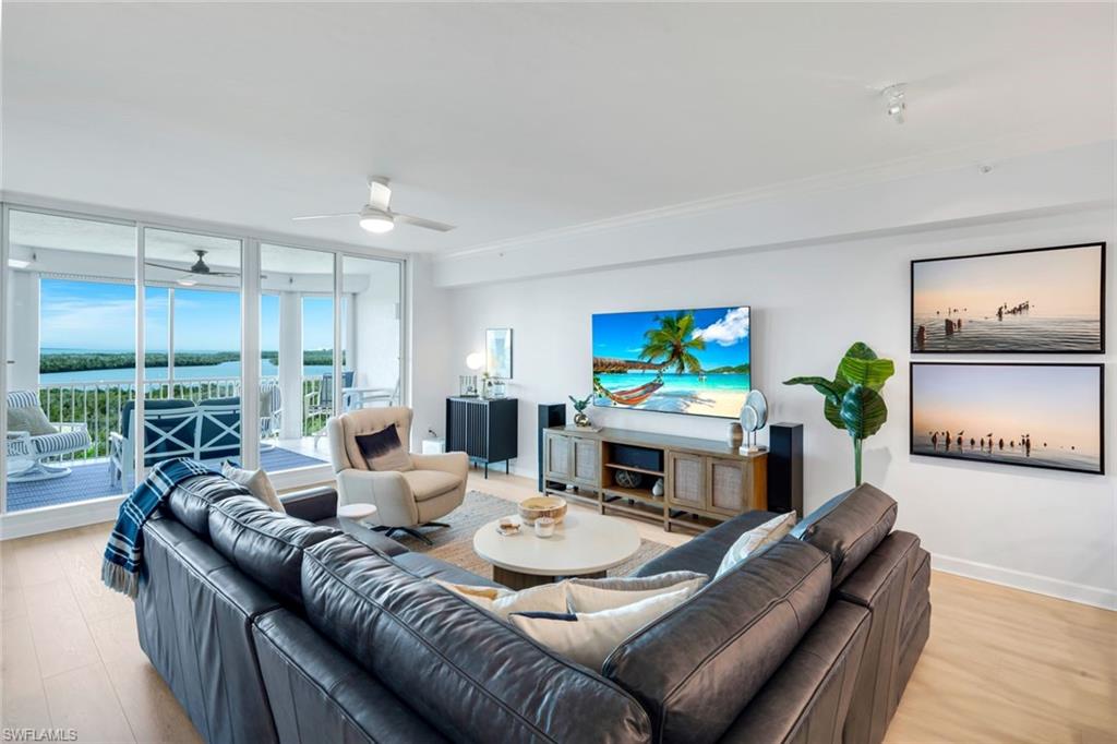 325 Dunes Boulevard, Unit 604 Naples, FL 34110 - Photo 3 of 41 a living room with furniture a large window and a flat screen tv