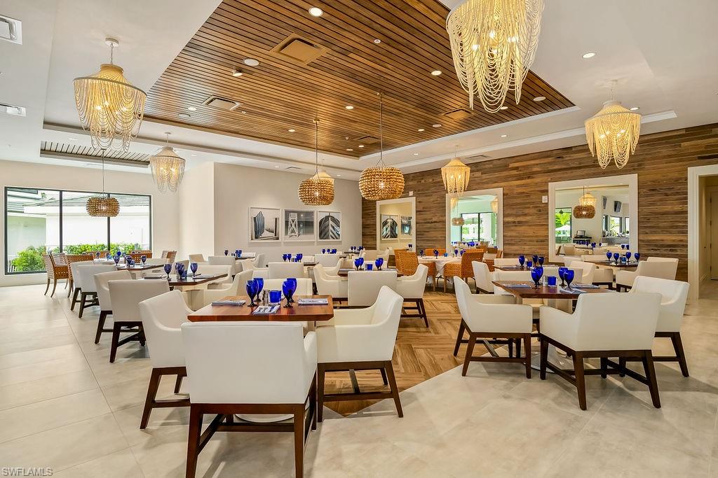 325 Dunes Boulevard, Unit 604 Naples, FL 34110 - Photo 35 of 41 a room with lots of furniture and a chandelier