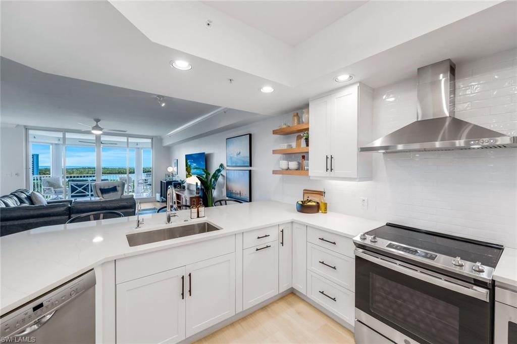 325 Dunes Boulevard, Unit 604 Naples, FL 34110 - Photo 7 of 41 a kitchen with a sink stainless steel appliances and cabinets