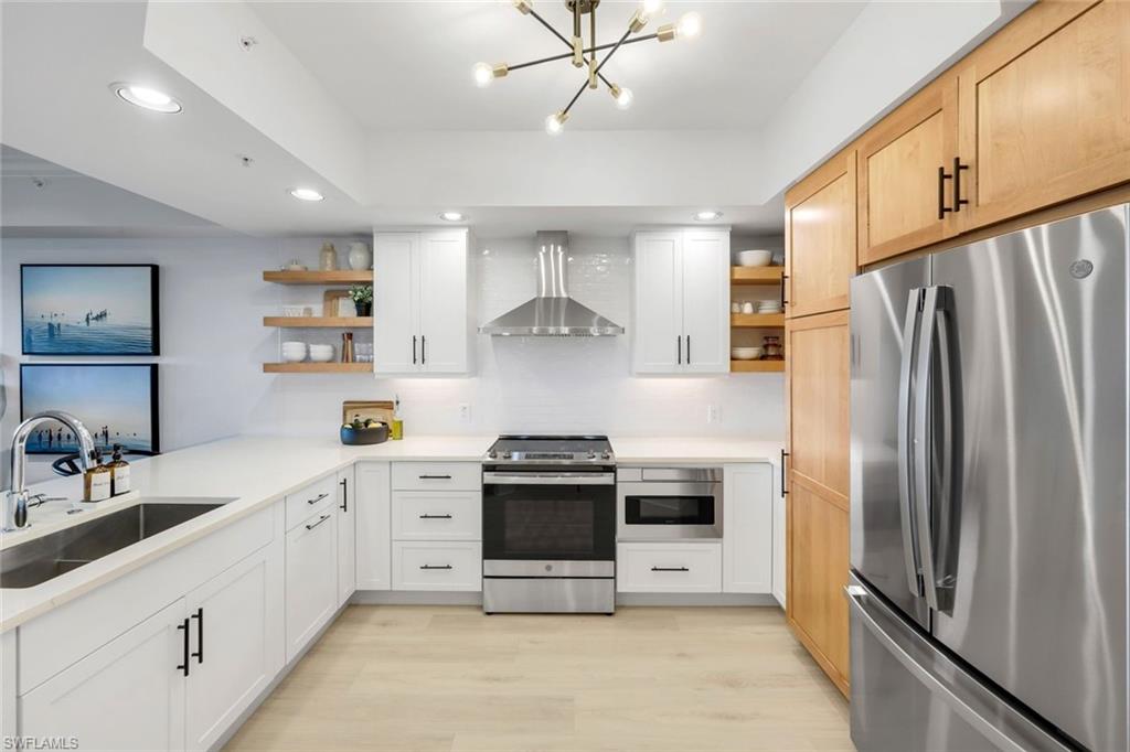 325 Dunes Boulevard, Unit 604 Naples, FL 34110 - Photo 10 of 41 a kitchen with stainless steel appliances a stove a sink and a refrigerator