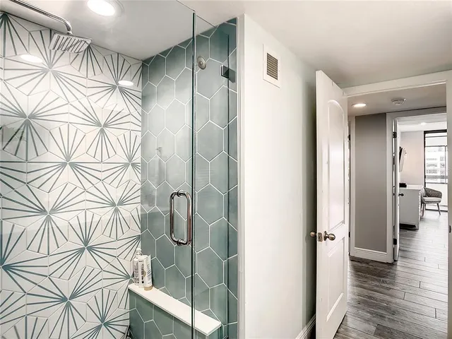 a bedroom with a large bed and a flat tv screen on dresser