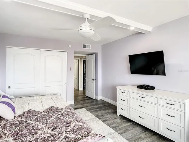 a bedroom with a bed and a ceiling fan