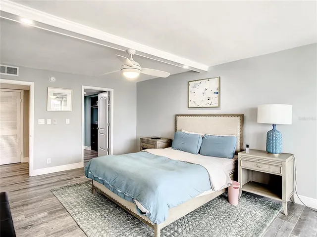 a spacious bedroom with a bed and a flat screen tv