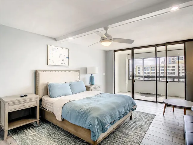 a bedroom with a bed a large window and a flat screen tv