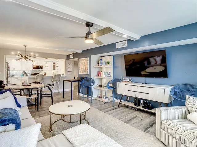 a living room with furniture and a dining table with wooden floor