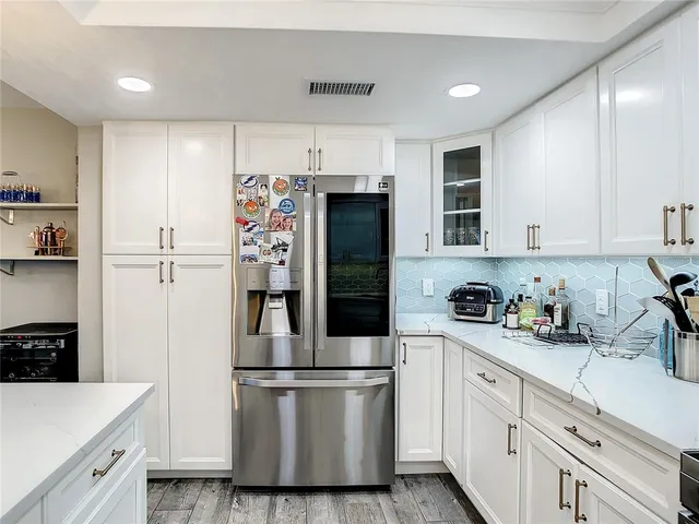 a kitchen with stainless steel appliances granite countertop a refrigerator and a stove top oven