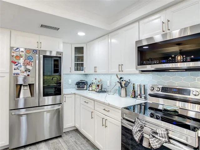 a kitchen with a sink stove and white cabinets