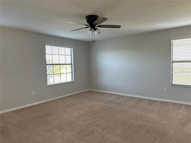 an empty room with a window and a fan