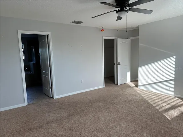 a view of a livingroom with a ceiling fan and window