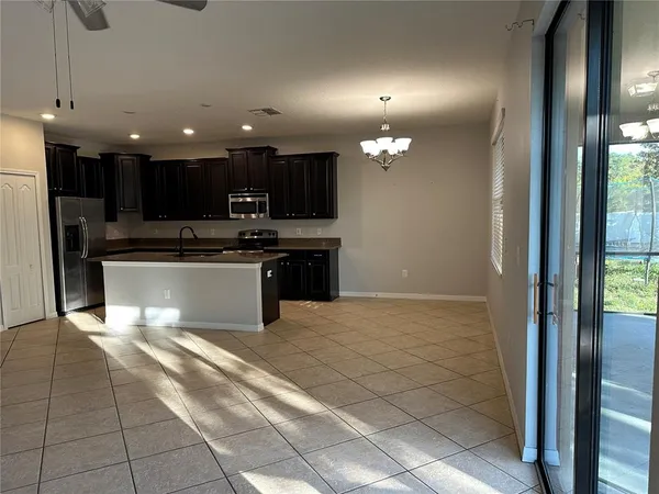 a large kitchen with stainless steel appliances granite countertop a refrigerator and a sink