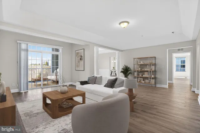 a view of an empty room with wooden floor and windows