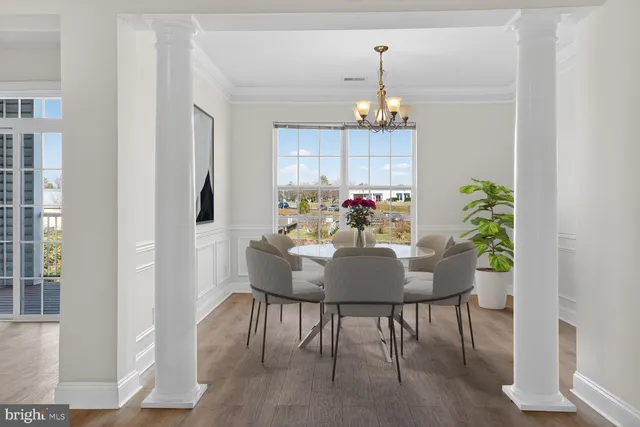 a dining room with furniture a chandelier and wooden floor